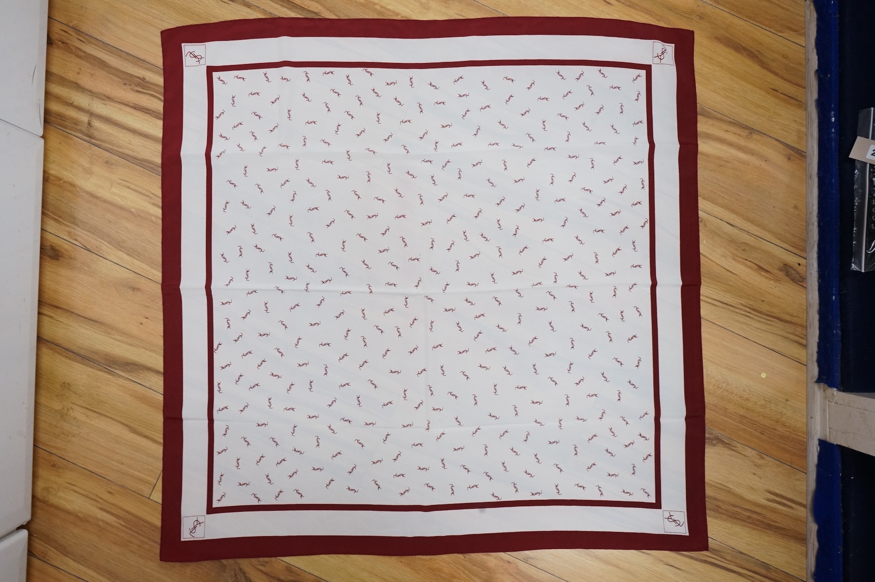 Two Yves Saint Laurent silk scarves comprising a monogrammed example and a patterned brown example with Foulards folding case